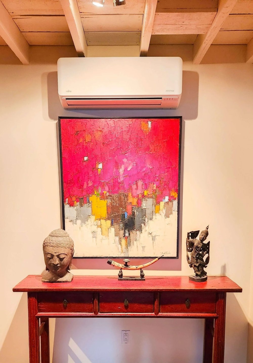FUJITSU AIRSTAGE Aquila XLTH wall head installed by AirGreen above a red abstract painting, under a beamed ceiling, in La Présentation